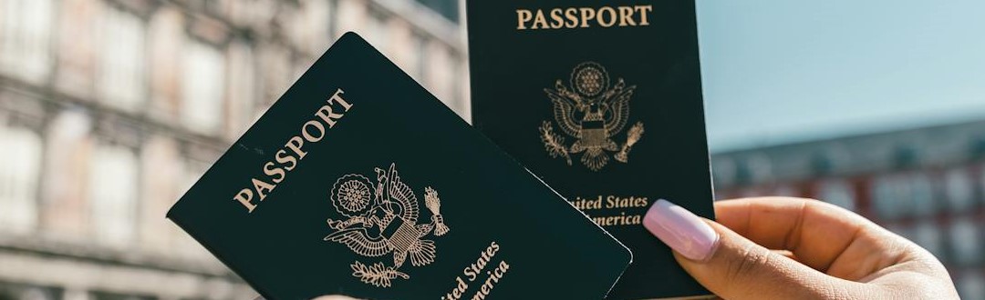 Anonymous tourists showing US passports on street on sunny day.